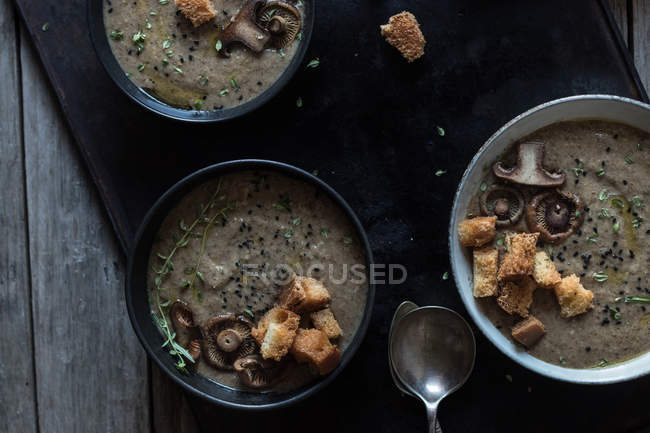 Mushroom cream soup with croutons in bowls on tray on dark background — Stock Photo