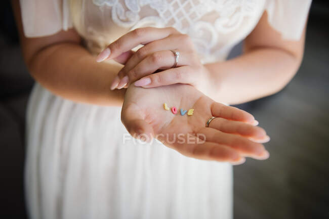 Novia mostrando palabra amor en sus manos - foto de stock