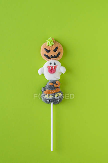 Caramelos de Halloween en palo sobre fondo verde - foto de stock