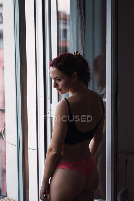 Jeune femme sensuelle en lingerie debout au balcon — Photo de stock