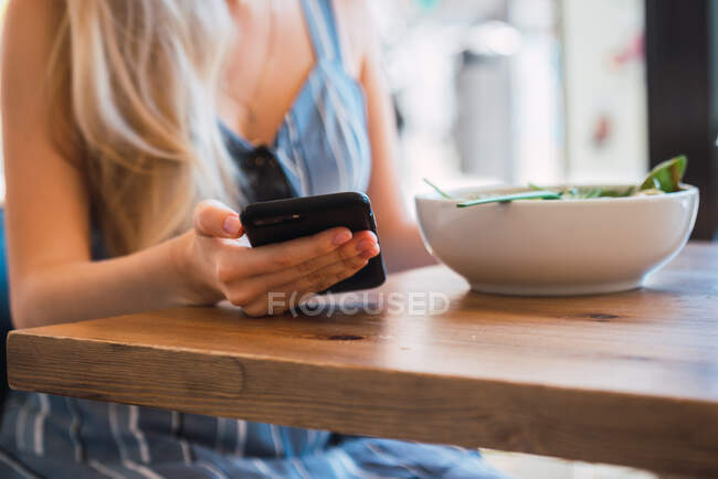 Mulher que navega smartphone no café — Fotografia de Stock