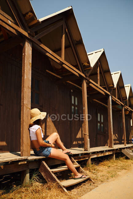 Tourist woman leaning on wooden building — Stock Photo