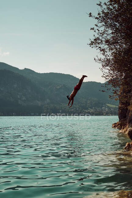Человек прыгает в воду — стоковое фото