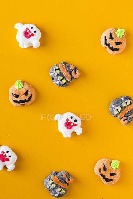 Doces de Halloween decorados no fundo laranja — Fotografia de Stock