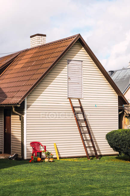 Ladder  near wall of countryside cottage in small settlement on cloudy day — Stock Photo