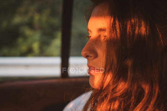 Vista laterale di bella giovane donna tenere gli occhi chiusi mentre seduto all'interno del veicolo moderno durante il viaggio attraverso la Bulgaria, Balcani — Foto stock