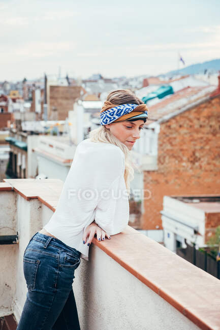 Jovem mulher em kerchief na cabeça de pé no telhado — Fotografia de Stock