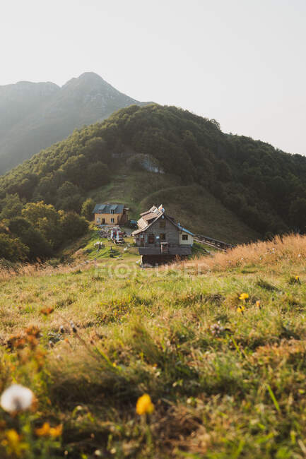 Pintoresca vista de pequeñas casas de pie en la cima de la colina verde en el día soleado en Bulgaria, Balcanes - foto de stock