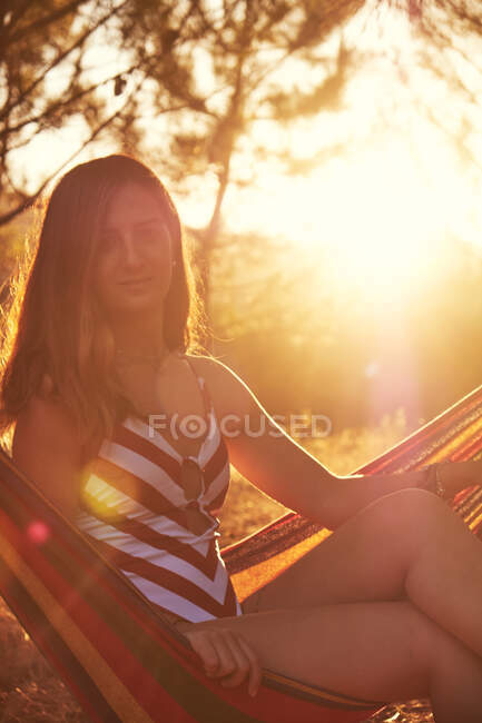 Tanned female on hammock at sunny glade — Stock Photo