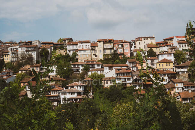 Belle case e alberi situati sul pendio della collina in splendida giornata nuvolosa in Bulgaria, Balcani — Foto stock