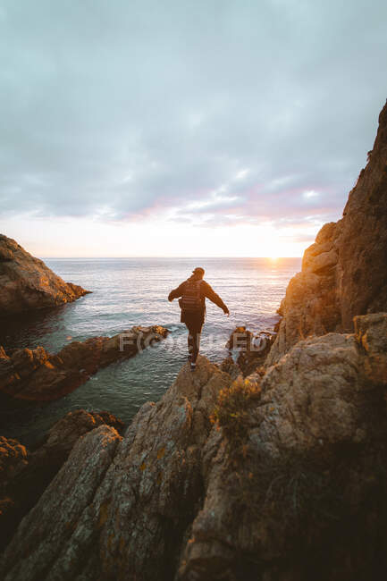 Неузнаваемый человек, стоящий на скале у моря — стоковое фото