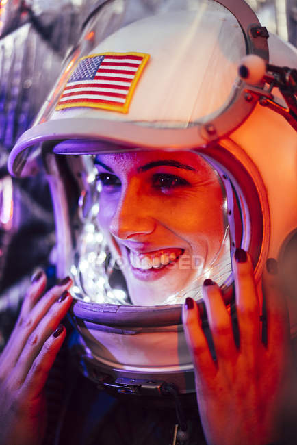 Menina sorrindo vestindo capacete antigo espaço com sinal de bandeira americana — Fotografia de Stock