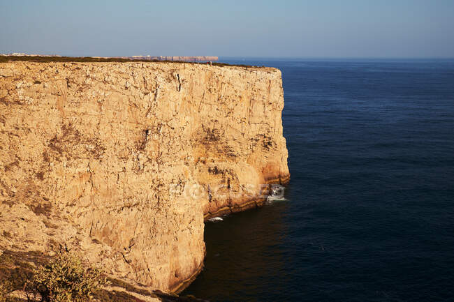 Côte de la mer avec de hautes falaises et l'eau bleue — Photo de stock