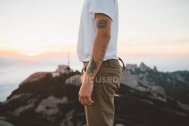 Красивый мужчина с камерой, стоящий на скале — стоковое фото