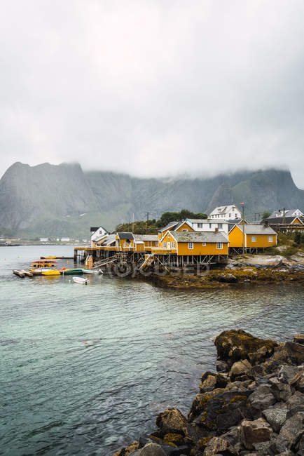Small village on rocky shore in mountains in overcast — Stock Photo
