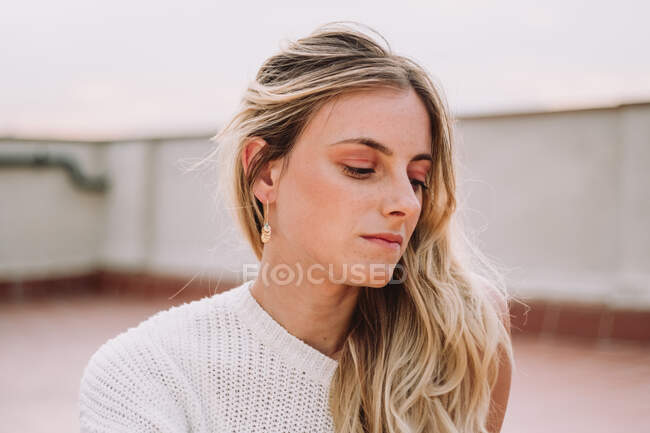 Beautiful woman with fair hair posing on rooftop — Stock Photo