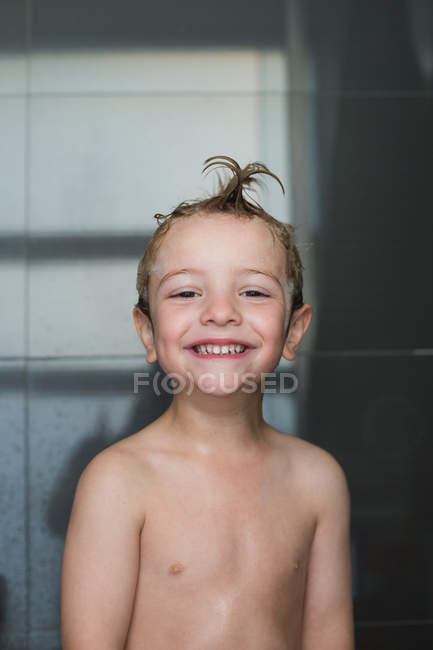 Ritratto di allegro bambino in piedi sotto la doccia con i capelli bagnati — Foto stock
