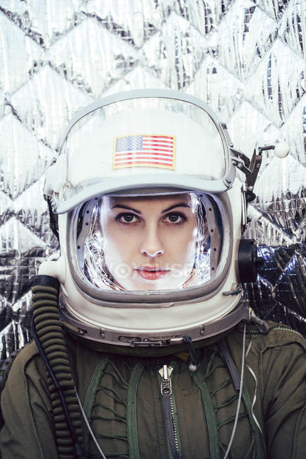 Menina confiante vestindo capacete antigo espaço com sinal de bandeira americana no fundo folha — Fotografia de Stock