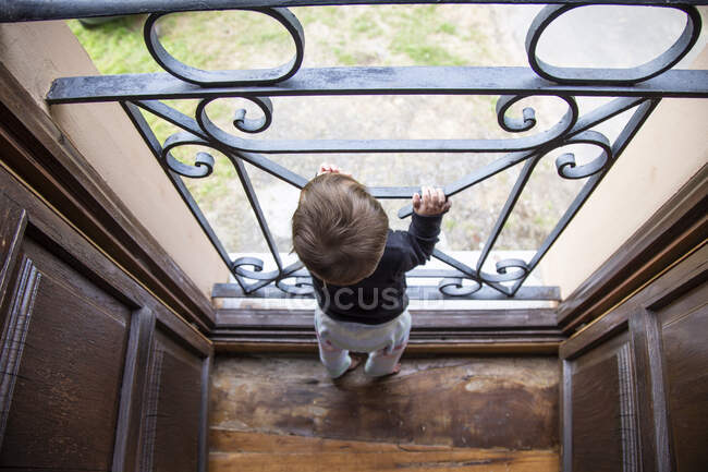 Säugling schaut neugierig in Tür — Stockfoto