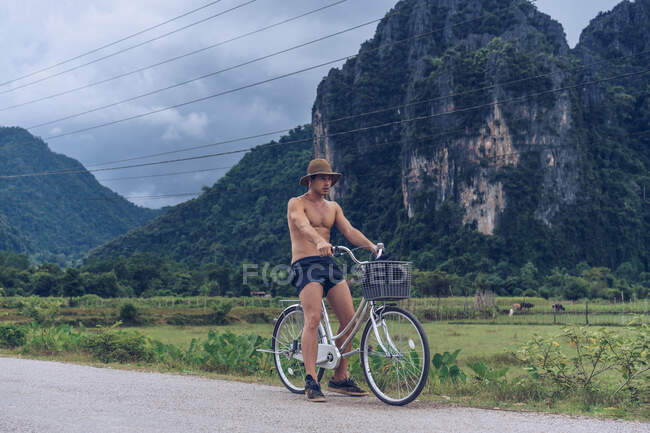 Homem de bicicleta na estrada rural — Fotografia de Stock