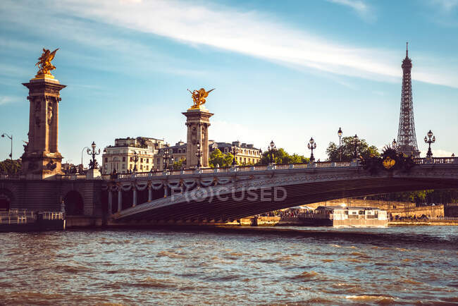 Große Flussbrücke mit Laternen unter blauem bewölkten Himmel in Paris — Stockfoto