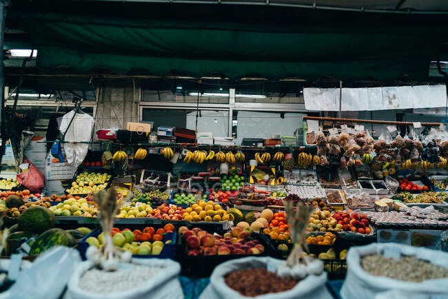 Contador en el mercado con surtido de frutas jugosas de colores. - foto de stock