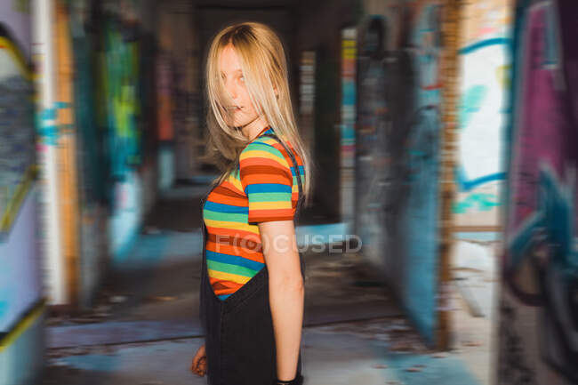 Young girl standing in destroyed building — Stock Photo