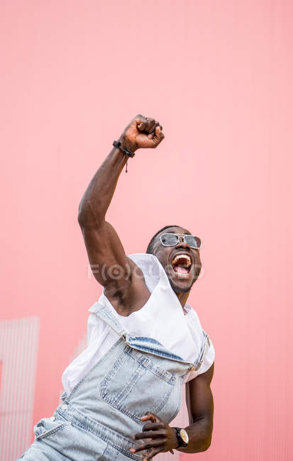 Funky uomo felice in gloria con pugno serrato su sfondo colorato — Foto stock