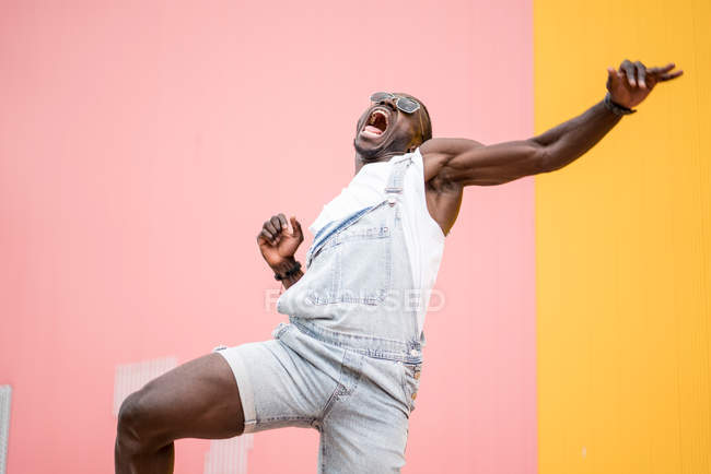 Funky uomo felice in gloria con pugno serrato su sfondo colorato — Foto stock
