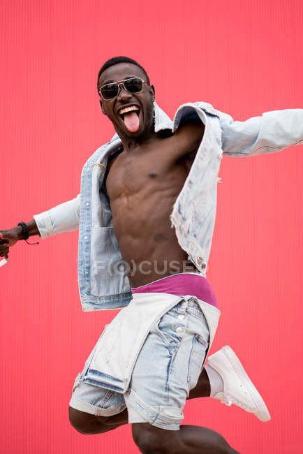 African american man dancing on red background — Stock Photo