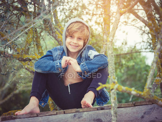 Young fashionable boy on fence — Stock Photo