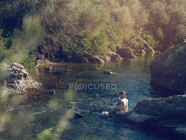 Молодий хлопець сидить і рибалить — стокове фото