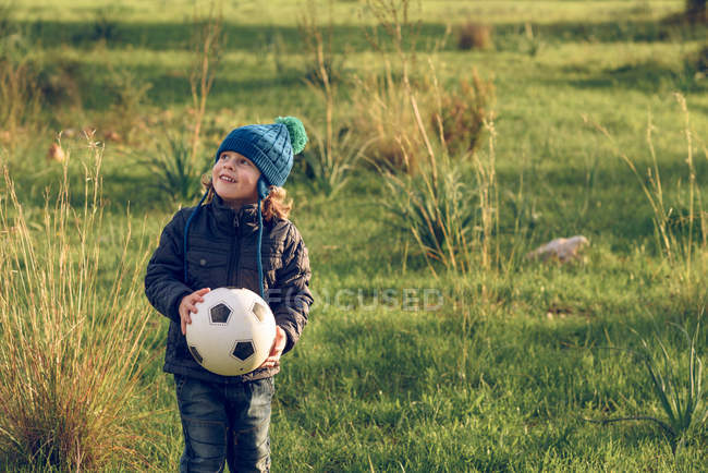 Niño con pelota en el campo - foto de stock