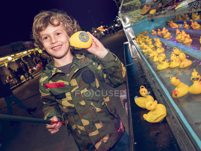 Мальчик ловит утку на ярмарке — стоковое фото