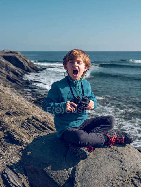Rapaz alegre com binóculos à beira-mar — Fotografia de Stock