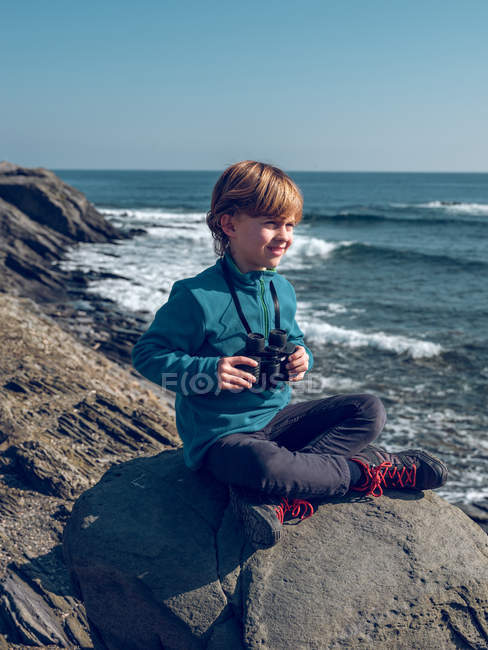Rapaz alegre com binóculos à beira-mar — Fotografia de Stock