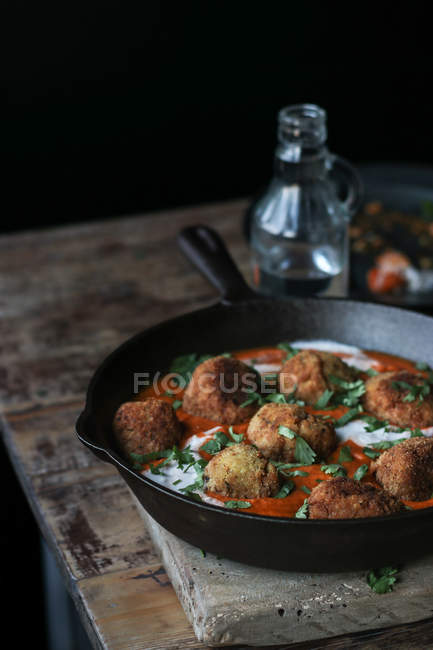 Cauliflower and quinoa balls with parsley and sauce in pan on wooden table — Stock Photo
