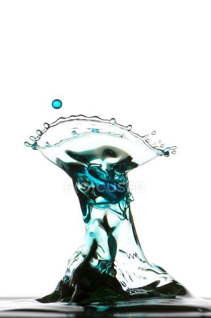 Closeup shot of splash of colorful transparent liquid on white background — Stock Photo