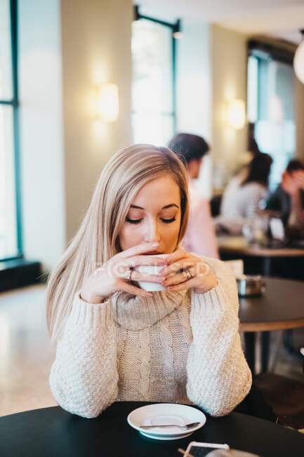 Junge Frau trinkt aus Tasse — Stockfoto