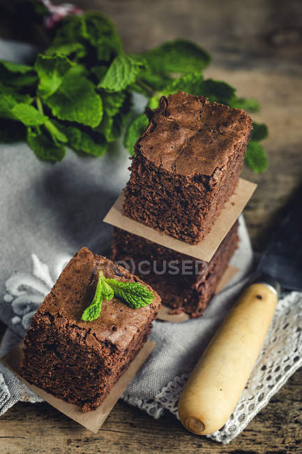 Pedaços de chocolate brownie com hortelã na mesa de madeira — Fotografia de Stock