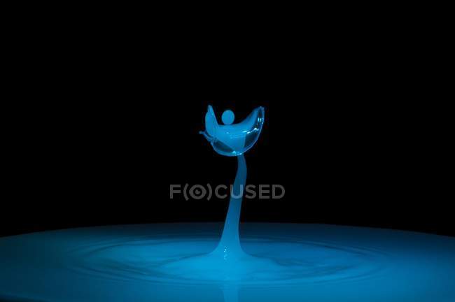 Primo piano di spruzzi di liquido blu di colore su sfondo nero — Foto stock