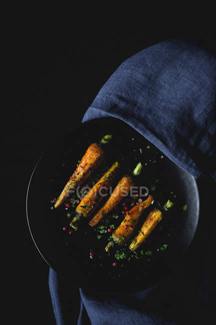 Healthy roasted carrots with herbs and spices on dark background — Stock Photo