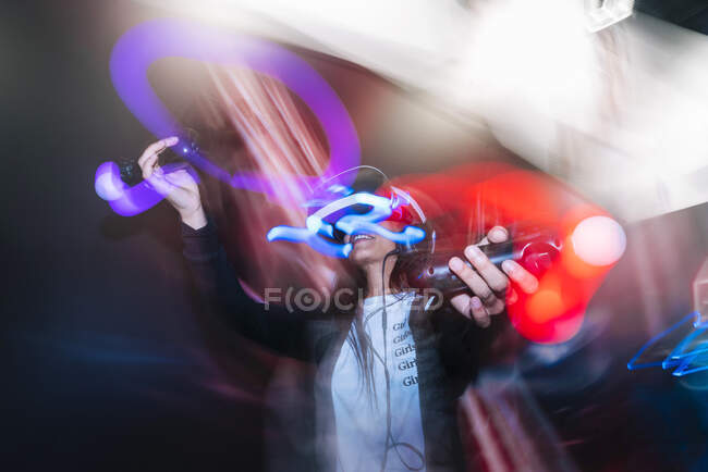 Woman playing video game in dark — Stock Photo