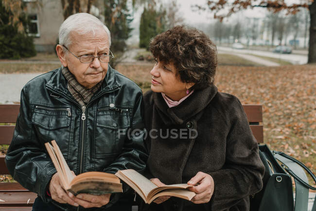 Старша пара читає книги в парку — стокове фото