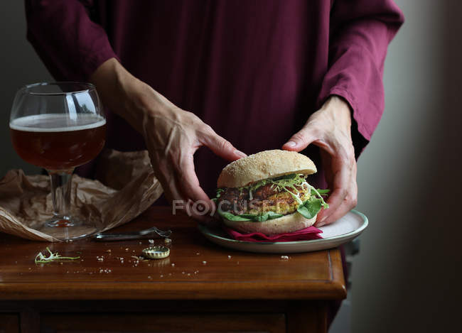 Крупним планом жінка насолоджується пивом і вегетаріанським бургер — стокове фото