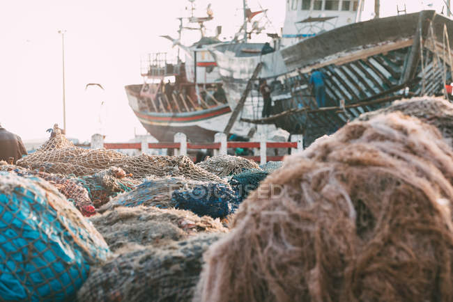 Fishing boats anchored with piles of fishnets in Essaouira, Morocco — Stock Photo