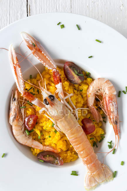 Paella caseira com lagostins e camarões servidos em prato branco — Fotografia de Stock