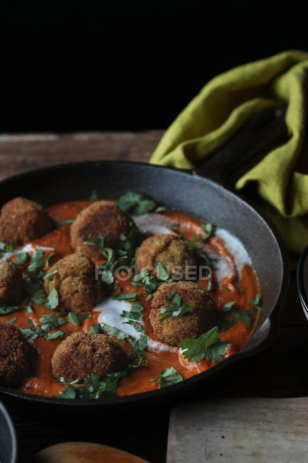 Pan with cauliflower and quinoa  balls in sauce on wooden table — Stock Photo