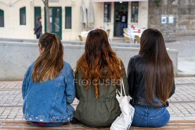 На вигляд молоді довговолосі жінки сидять на вулиці в Порто (Португалія). — стокове фото
