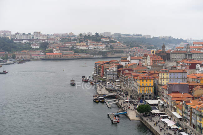 Сверху прекрасный вид на город со старыми зданиями и реку с плавающими кораблями в Порту, Португалия — стоковое фото
